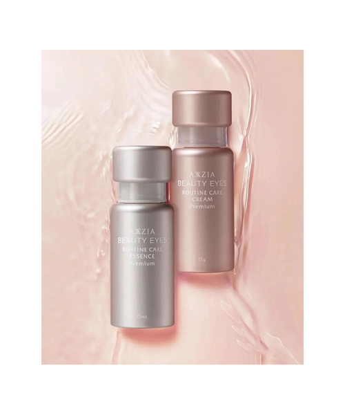 AXXZIA Beauty Eyes Routine Care Premium Cream i Essence – dwa flakony linii Beauty Eyes Routine Care Premium na różowym tle