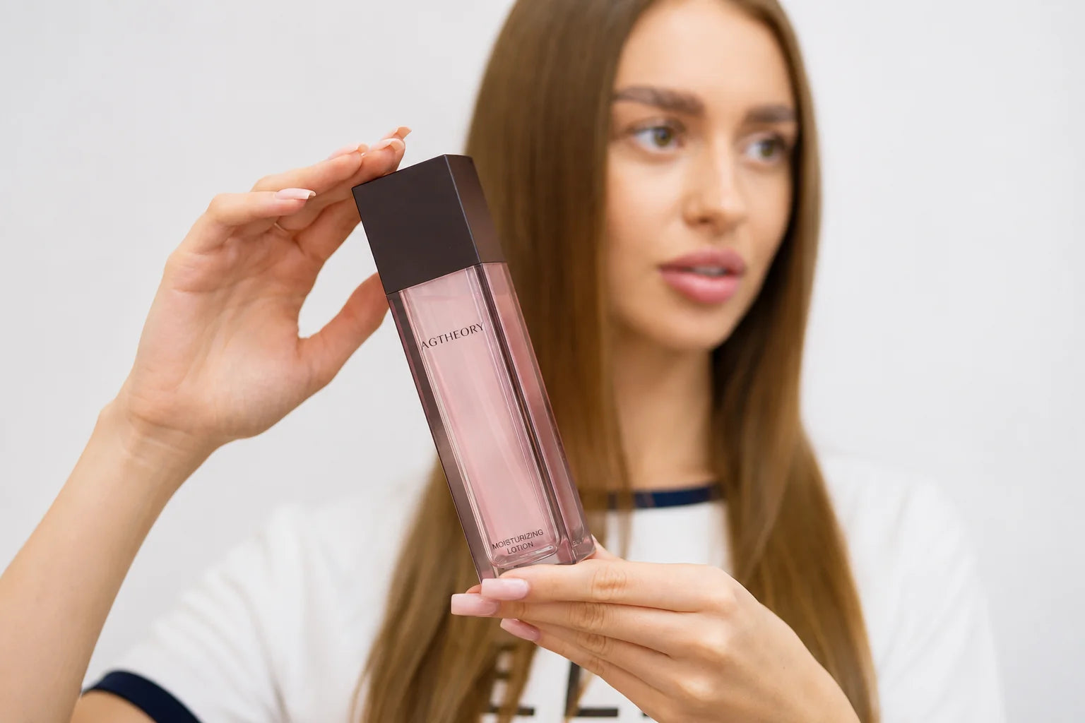 Kobieta trzymająca AGTHEORY Moisturizing Lotion - nawilżający lotion przygotowujący skórę na serum